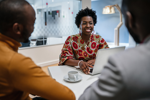 Traditional dressed black african business woman financial bank adviser in meeting with customer. African pattern